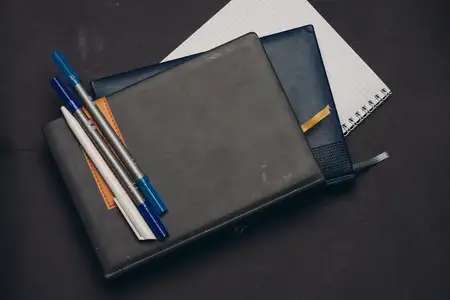 Блокноты, документы, письменный стол, ручки, офисные принадлежности на сером фоне