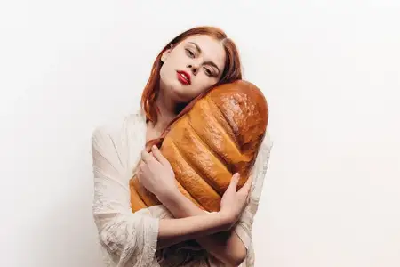 Красивая женщина обнимает батон руками, макияж, прозрачная ткань на плечах