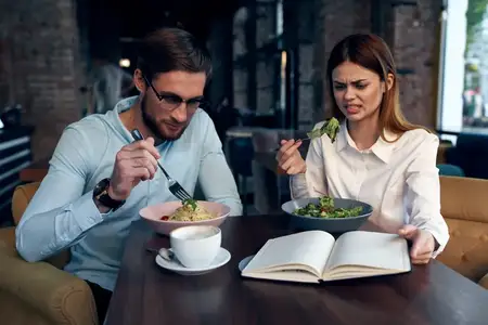 Мужчина и женщина, коллеги по работе, завтракают в кафе и общаются