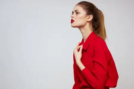 Красивая девушка с красными губами и в рубашке на светлом фоне