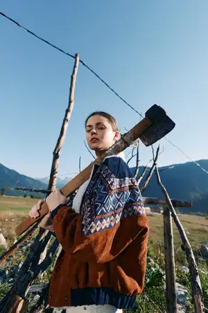 Женщина, топор, забор, горы, поле, свитер, деревенский фермерский портрет, демонстрирующий традиционный трикотаж и деревенский образ жизни