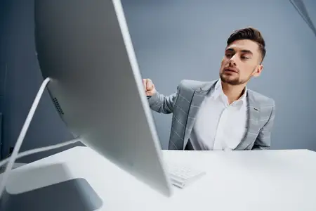 Красивый мужчина работает за компьютером в офисе, технологии