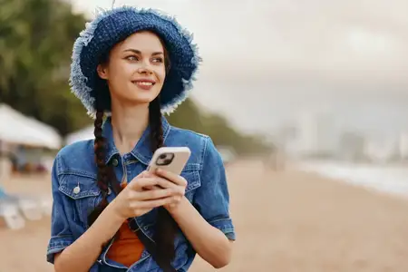 Молодая девушка пользуется смартфоном в городском парке