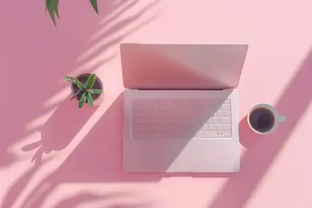 Необходимые для работы предметы на розовом фоне: ноутбук, растение и чашка кофе