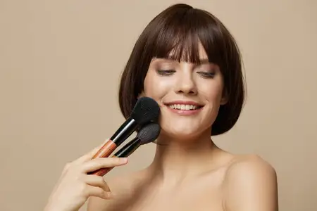 Брюнетка с короткой стрижкой улыбается и излучает шарм на бежевом фоне