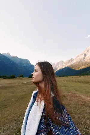 Портрет женщины в профиль на фоне горного пейзажа и луга