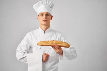 Мужчина в форме повара, пекарь с батоном в руках, свежий продукт