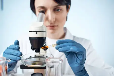 Женщина-ученый работает с микроскопом, проводя микробиологические исследования крупным планом