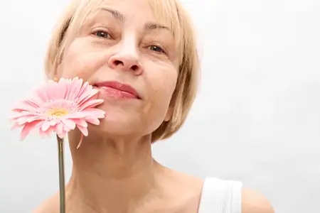 Женщина, цветок, крупный план, весна, красота, природа, портрет, блондинка, женский пол, зрелое лицо с розовым цветком, отдых на свежем воздухе, спокойствие и благополучие, уход за кожей и забота о…