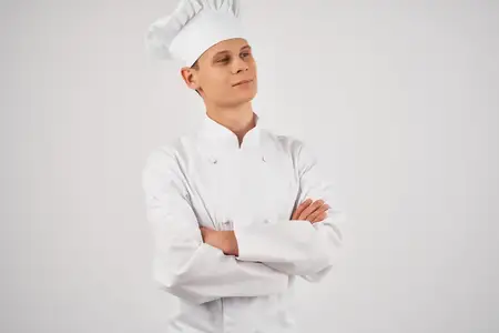 Шеф-повар мужского пола занимается приготовлением пищи, работая профессионально