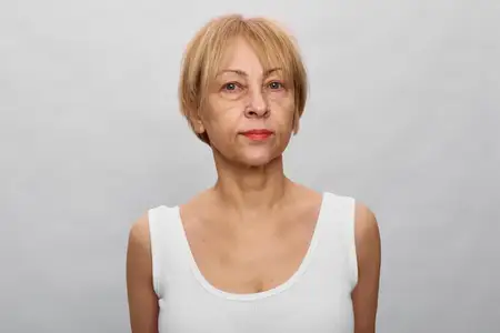 Портрет пожилой женщины на студийном сером фоне