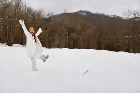 Молодая женщина в зимней одежде и шапках находится на улице, вокруг много снега