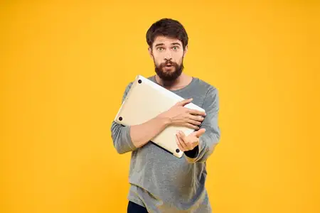 Мужчина с ноутбуком, беспроводные технологии, интернет, образ жизни, работа, изолированный жёлтый фон