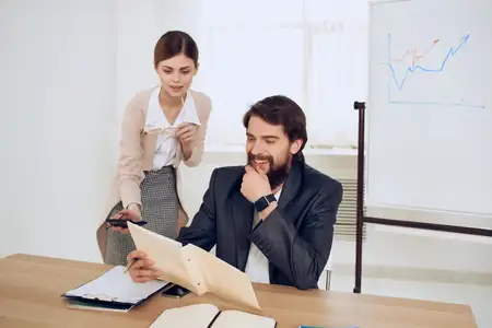 Коллеги по работе общаются за рабочим столом в офисе, на снимке переданы эмоции