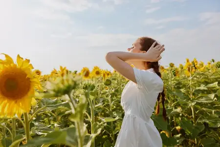 Женщина с косичками в белом платье любуется природным пейзажем