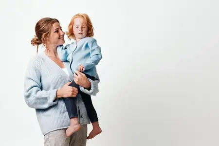 Счастливый семейный момент: мать держит дочь на руках с улыбкой