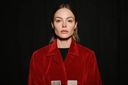 Портрет утонченной модели-женщины в яркой красной бархатной куртке, передающий сильные эмоции в темной обстановке