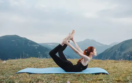 Спортивная женщина на природе занимается йогой на фоне гор