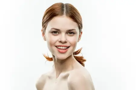 Симпатичная женщина с обнаженными плечами, косметика, собранные волосы, привлекательный взгляд