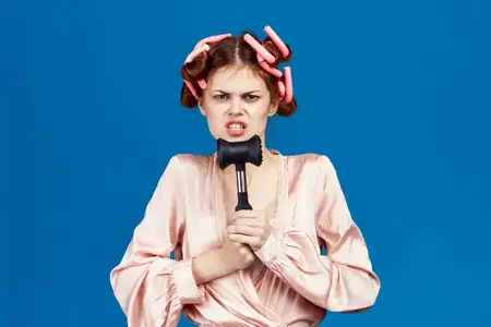 Женщина с бигуди на голове, в розовом халате, с молотком для отбивания мяса, домохозяйка, синий фон