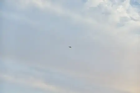 Самолёт летит в небе на фоне облаков в солнечный день