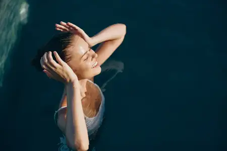 Сцена купания на открытом воздухе: радостное выражение лица, объятие воды, повседневный стиль, естественные цвета, непринуждённая съёмка, тепло солнца, летний досуг, атмосфера бассейна…