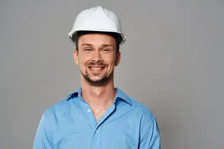 Весёлый инженер-строитель в каске на голове, безопасная работа