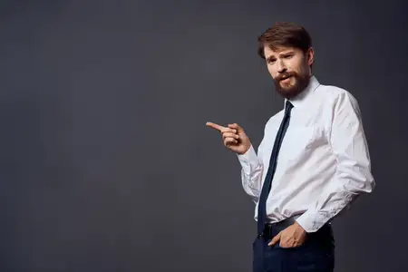 Менеджер держит галстук в деловом офисе на тёмном фоне