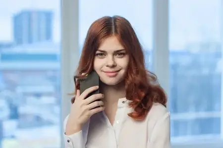 Веселая женщина-менеджер с телефоном в руках
