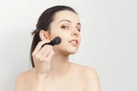 Женщина с обнаженными плечами, маска для лица, кисть для нанесения ухода за кожей