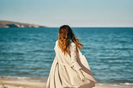 Женщина путешествует, отдыхает на море, песчаном пляже, среди гор, дышит свежим воздухом