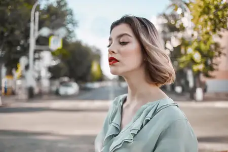 Милая блондинка прогуливается в парке, наслаждаясь свежим воздухом