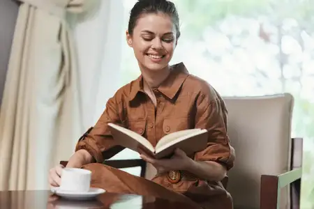 Молодая жизнерадостная женщина с удовольствием читает книгу