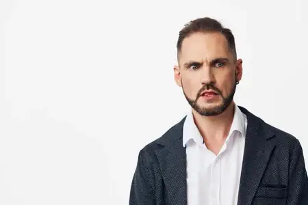 Студийный снимок мотивированного руководителя в элегантной одежде, демонстрирующего решимость и лидерство, на изолированном цветном фоне, который подчеркивает профессионализм и основные деловые…