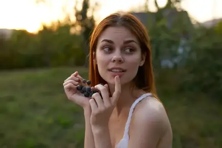 Женщина ест виноград на природе, да, органический