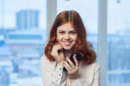 Женщина-менеджер в офисе разговаривает по телефону