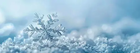 Прекрасно детализированная снежинка лежит на снежном покрове, запечатленная на спокойном синем фоне, вызывающая красоту зимы