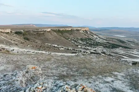 Живописный вид на засушливые луга с величественными горами вдалеке под ясным голубым небом