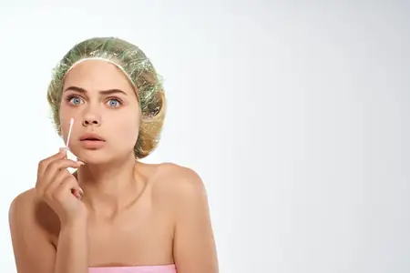 Женщина с обнаженными плечами, чистой кожей и розовым полотенцем, ухаживающая за лицом