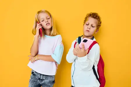Подростки, мальчик и девочка, смотрят в смартфон и играют в игры