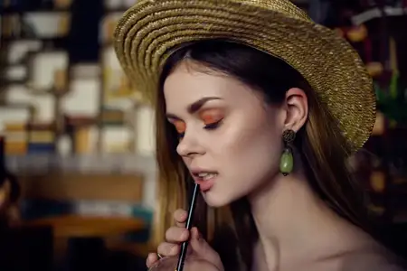 Красивая женщина сидит за столиком в кафе с напитком