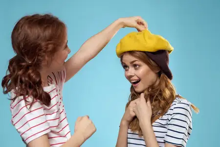 Забавные мама и дочь в студии, мода, стиль жизни, веселье на голубом фоне, семья