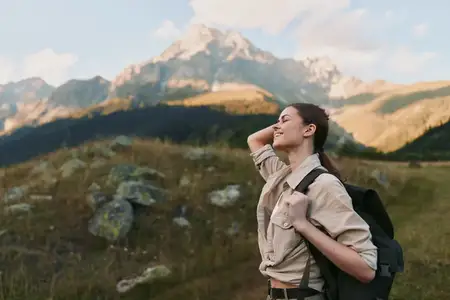 Портрет женщины в походной одежде на фоне альпийского пейзажа