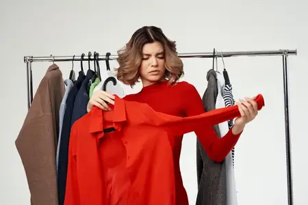 Симпатичная женщина рядом с одеждой, мода, веселье, розничная торговля, эмоции