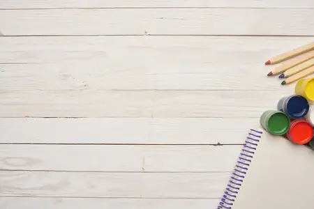 Акварельные краски, блокнот, инструменты для рисования на деревянном фоне