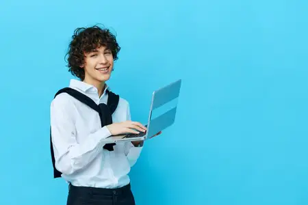Студент использует ноутбук для онлайн-общения в чате, что отражает интернет-технологии и современный образ жизни