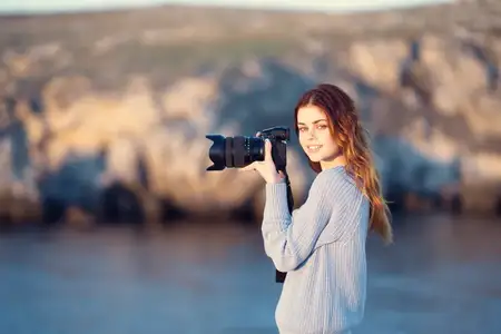 Женщина с фотоаппаратом в руках, профессиональная фотография, скалистые горы, путешествие