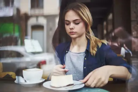 Женщина пьет кофе, отдыхая за утренним перекусом в ресторане