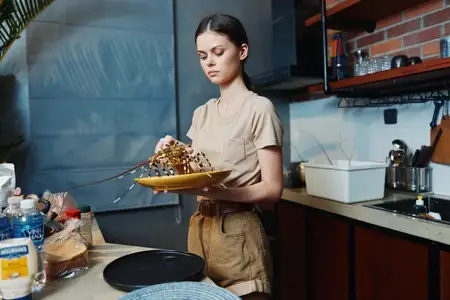 Женщина стоит посреди кухни, держа тарелку с едой, и готовит обед в уютной домашней обстановке