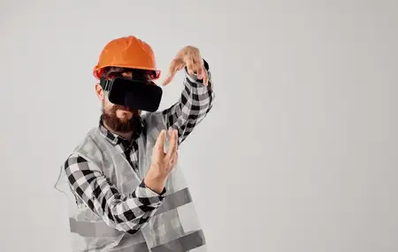 Строитель в оранжевой каске и 3D-очках жестикулирует руками